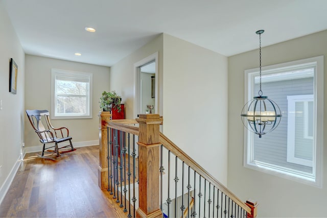 hallway with an inviting chandelier, wood finished floors, an upstairs landing, baseboards, and recessed lighting