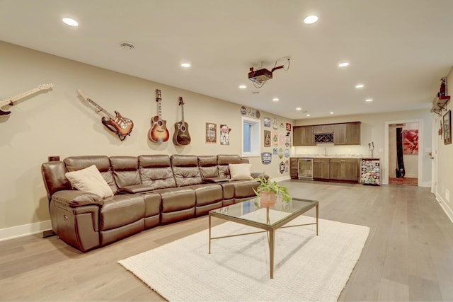 living room featuring wine cooler, light wood-style flooring, indoor bar, and recessed lighting