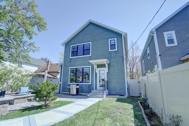 view of front of home featuring a front lawn, a fenced backyard, and a gate
