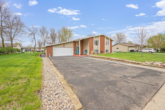 view of front of house featuring brick siding, an attached garage, a front yard, and aphalt driveway