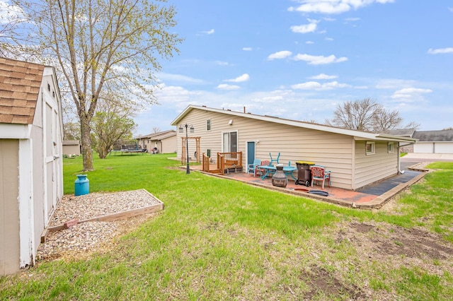 back of property featuring a lawn and a wooden deck