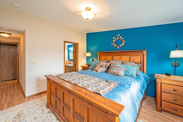 bedroom featuring a textured ceiling, baseboards, and light wood finished floors