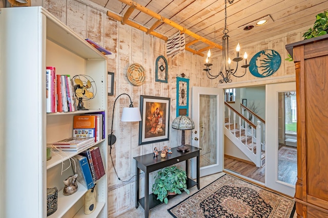 foyer featuring a notable chandelier, stairway, and wooden ceiling