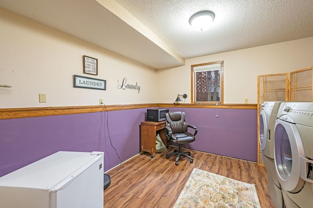 laundry room with independent washer and dryer, a textured ceiling, laundry area, and wood finished floors