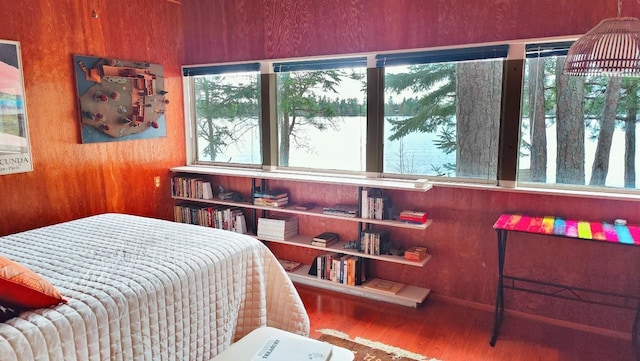 bedroom with multiple windows and wood finished floors
