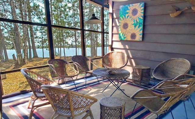 sunroom featuring a water view