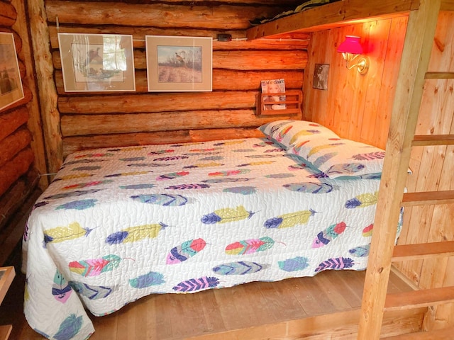 bedroom with rustic walls and wood finished floors