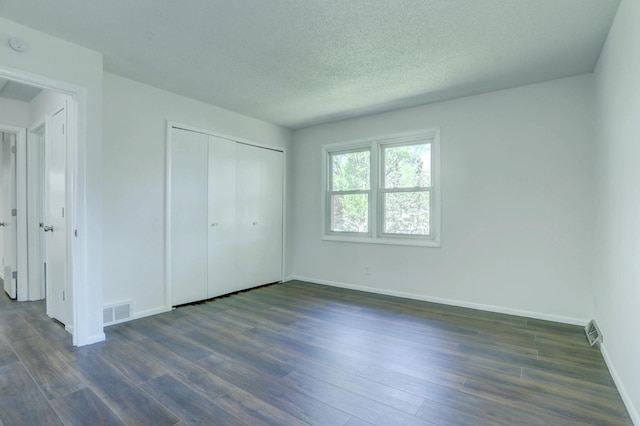 2401 Brookview Dr, Burnsville, MN 55337 - unfurnished bedroom with baseboards, dark wood-style flooring, a closet, and a textured ceiling