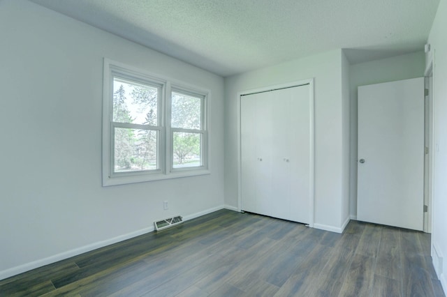 2401 Brookview Dr, Burnsville, MN 55337 - unfurnished bedroom with dark wood finished floors, baseboards, a textured ceiling, and a closet