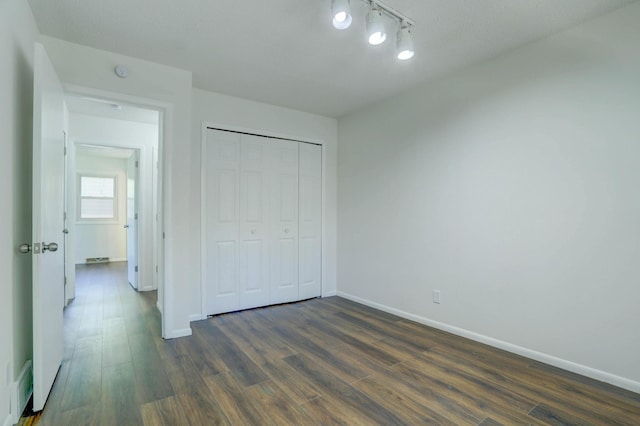 2401 Brookview Dr, Burnsville, MN 55337 - unfurnished bedroom featuring dark wood-type flooring, baseboards, a closet, and rail lighting
