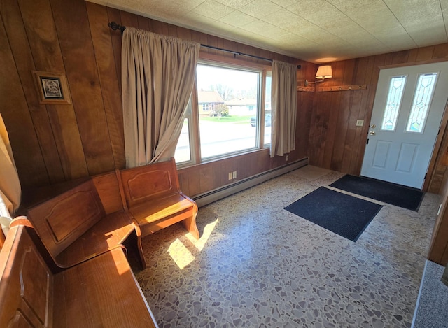 foyer featuring a baseboard radiator and wooden walls
