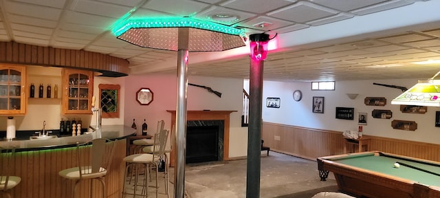 playroom featuring a drop ceiling, wainscoting, concrete flooring, wet bar, and billiards
