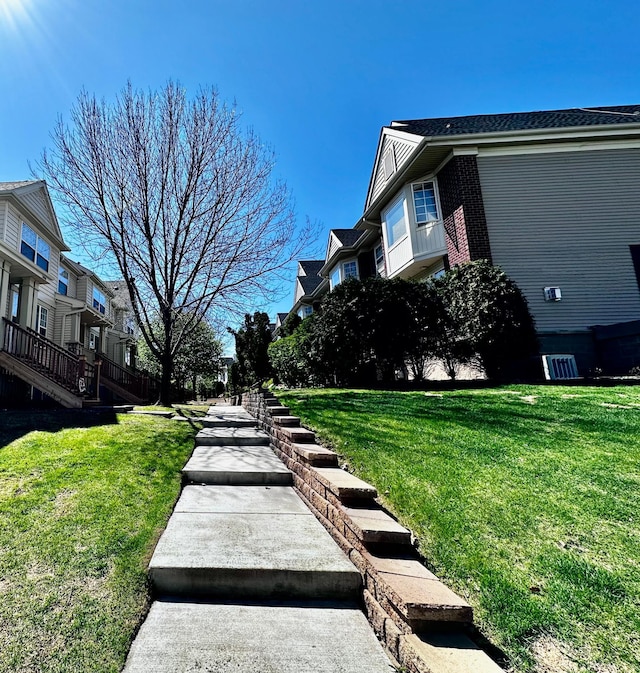 view of side of home with a lawn and brick siding