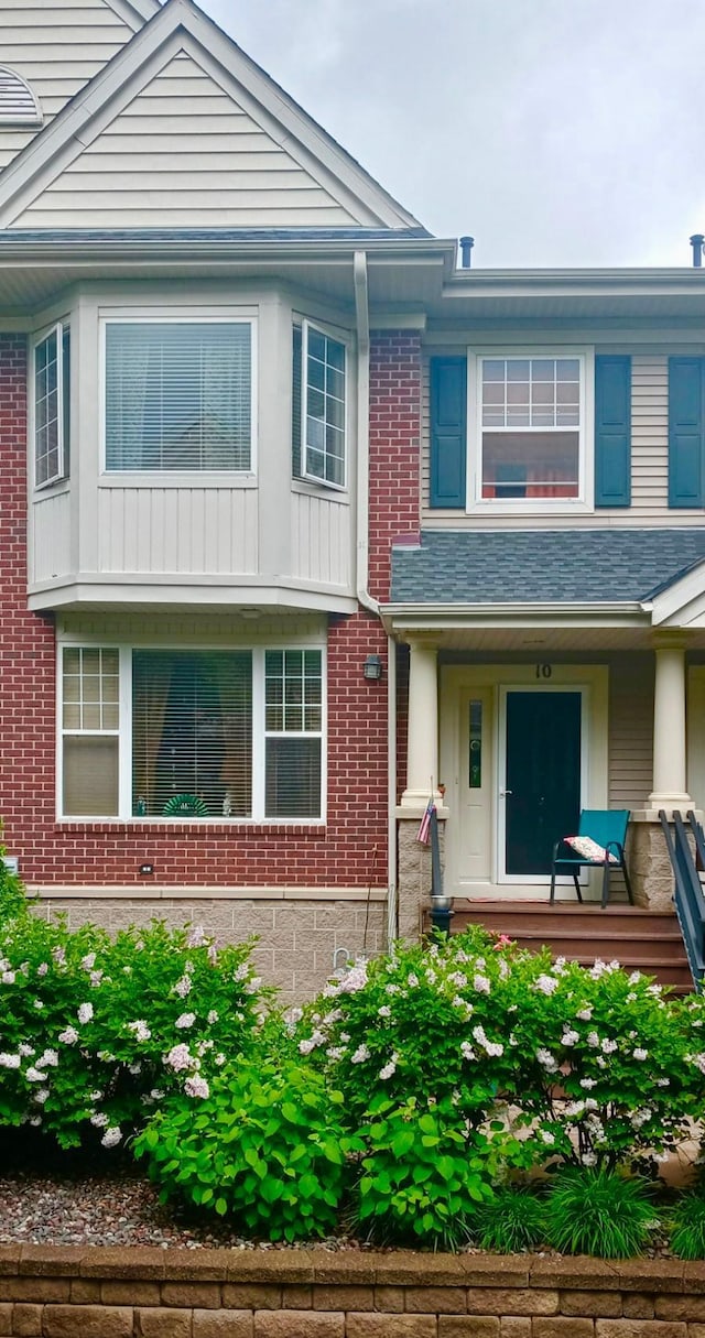 multi unit property featuring brick siding and covered porch