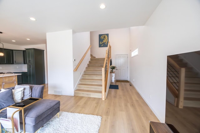4964 Big Goose Ln S, Fargo, ND 58104 - living room featuring stairway, light wood-style flooring, baseboards, and recessed lighting