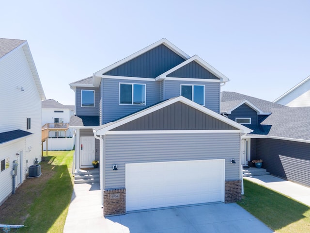 4964 Big Goose Ln S, Fargo, ND 58104 - craftsman-style home with board and batten siding, central AC unit, driveway, brick siding, and an attached garage