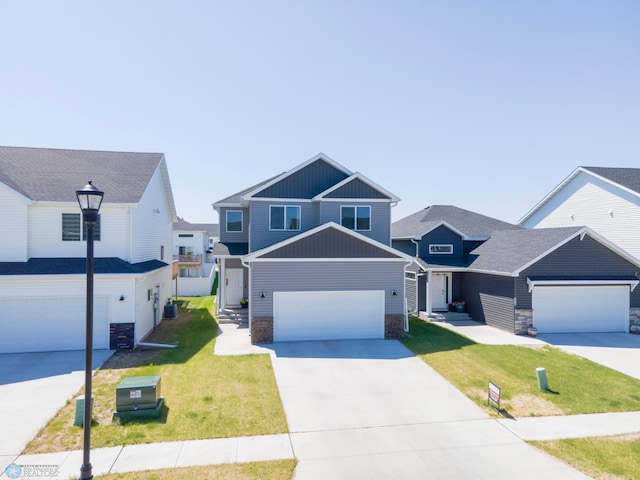 4964 Big Goose Ln S, Fargo, ND 58104 - view of front of home with board and batten siding, concrete driveway, a front yard, and stone siding