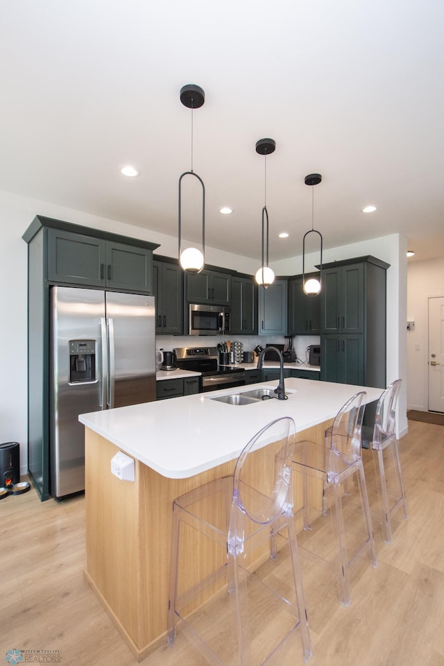4964 Big Goose Ln S, Fargo, ND 58104 - kitchen featuring stainless steel appliances, a sink, a kitchen breakfast bar, light wood-style floors, and light countertops