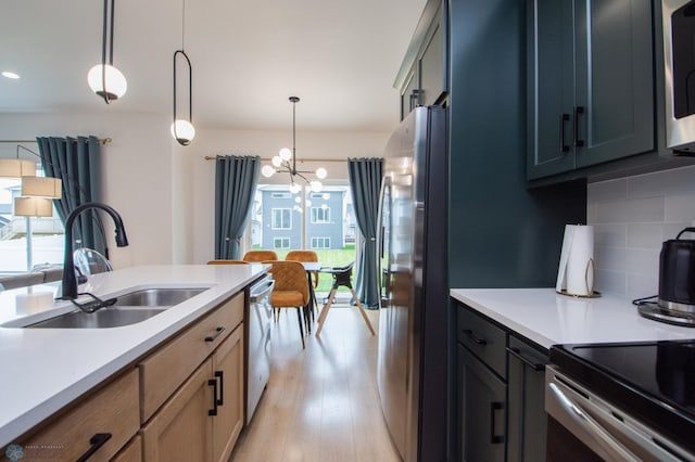 4964 Big Goose Ln S, Fargo, ND 58104 - kitchen featuring appliances with stainless steel finishes, healthy amount of natural light, a sink, and a chandelier