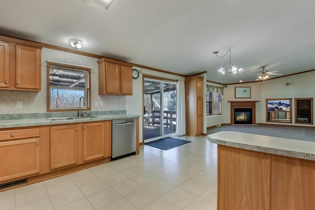 kitchen featuring stainless steel dishwasher, a sink, open floor plan, and ornamental molding