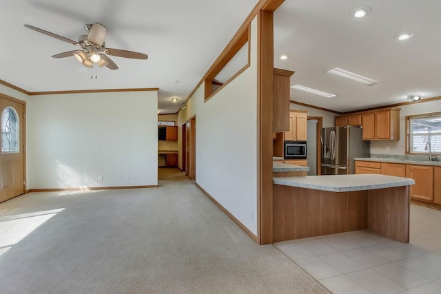 kitchen with ornamental molding, stainless steel appliances, a peninsula, and lofted ceiling