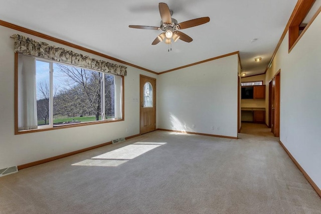 unfurnished room featuring visible vents, plenty of natural light, crown molding, and light colored carpet