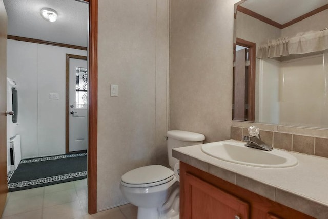 bathroom featuring vanity, ornamental molding, tile patterned flooring, and toilet