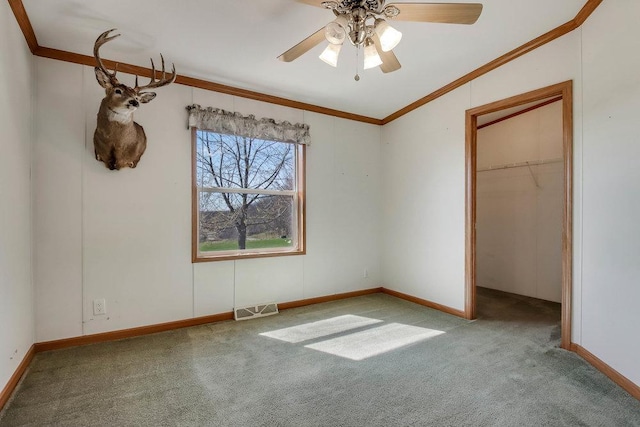 unfurnished bedroom featuring ceiling fan, visible vents, baseboards, ornamental molding, and carpet