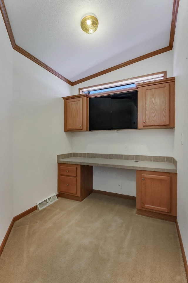 unfurnished office with crown molding, light colored carpet, visible vents, and built in study area