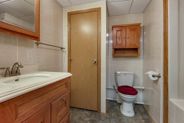 bathroom with tile walls, vanity, and toilet