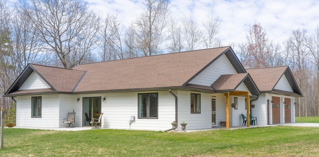 view of front of property with a garage, a shingled roof, driveway, and a front lawn