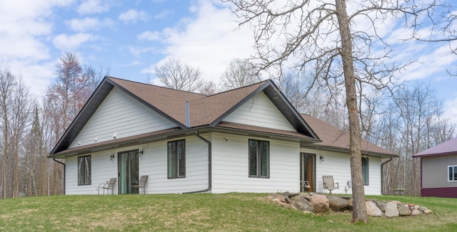 view of front of property featuring a front lawn and roof with shingles