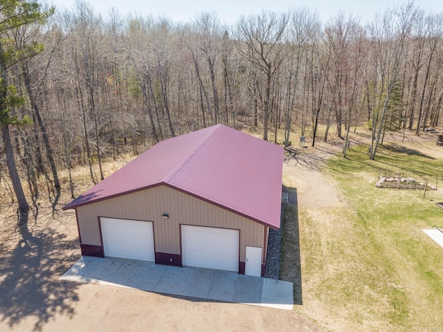detached garage with a wooded view and driveway