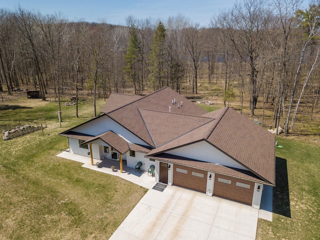 aerial view of property and surrounding area with a heavily wooded area