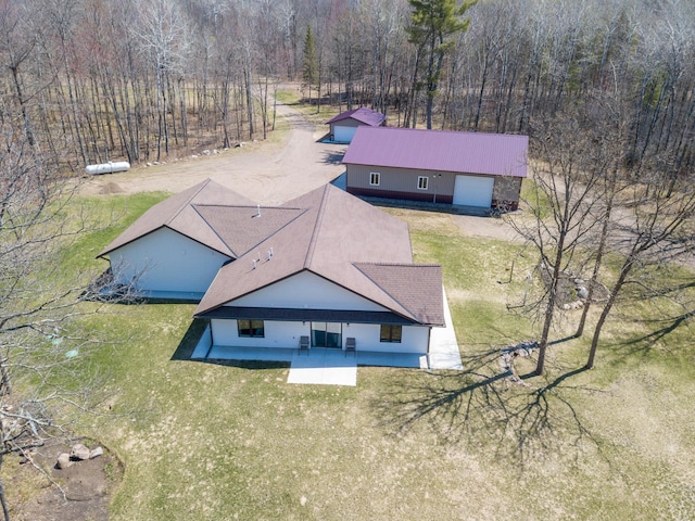 aerial view of property and surrounding area with a heavily wooded area