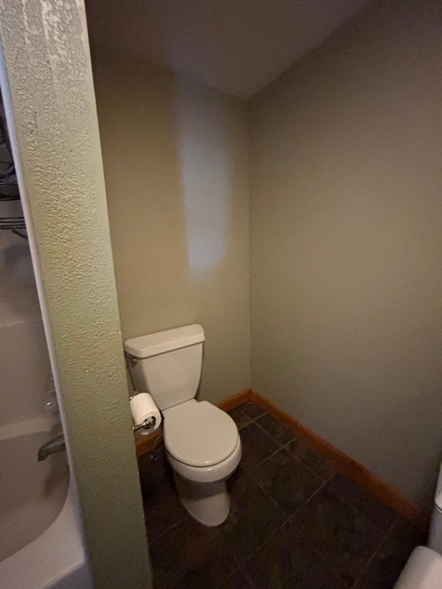 full bath featuring toilet, baseboards, and tile patterned floors