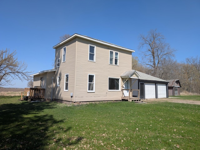 rear view of house with a lawn, driveway, and a garage