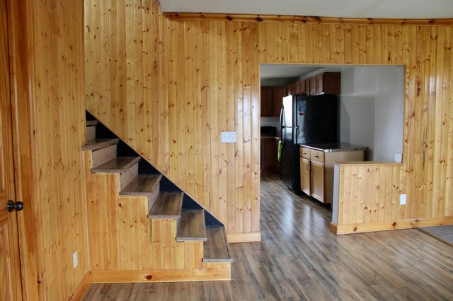 stairs featuring wood walls and wood finished floors