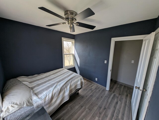 bedroom with wood finished floors, ceiling fan, and baseboards