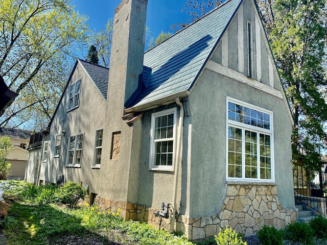 view of property exterior featuring stucco siding and a chimney