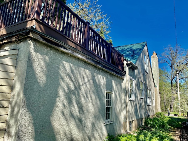 view of property exterior featuring a chimney and stucco siding