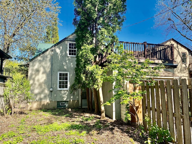 back of property featuring stucco siding and fence