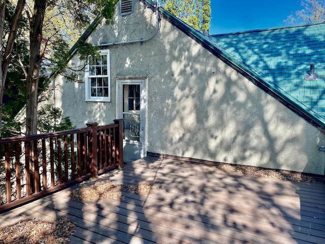 rear view of property with stucco siding and a deck