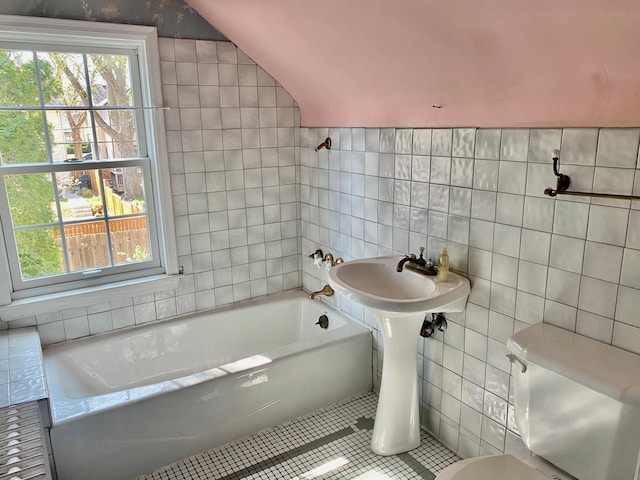 bathroom featuring tile walls, tile patterned floors, a tub to relax in, and a wealth of natural light