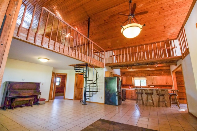 interior space with baseboards, stairs, light tile patterned flooring, and a towering ceiling