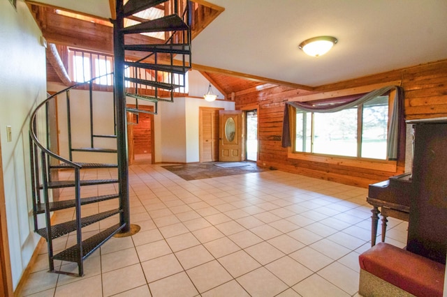 entrance foyer with light tile patterned floors, wood walls, lofted ceiling with beams, and stairs