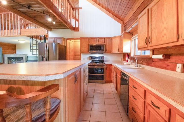 kitchen featuring a sink, a breakfast bar area, light countertops, wood ceiling, and appliances with stainless steel finishes