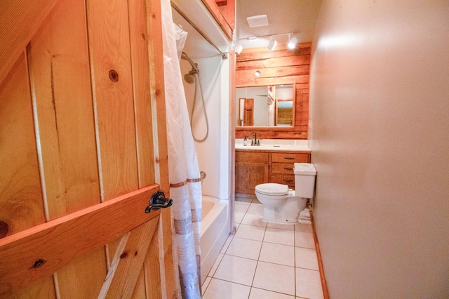 full bathroom featuring a sink, toilet, track lighting, tile patterned flooring, and shower / bathtub combination with curtain