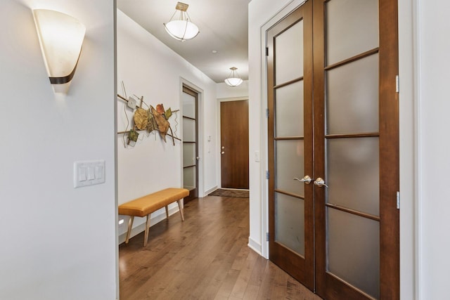 hallway with french doors, baseboards, and wood finished floors