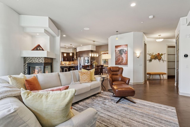 living area featuring baseboards, recessed lighting, wood finished floors, and a tiled fireplace